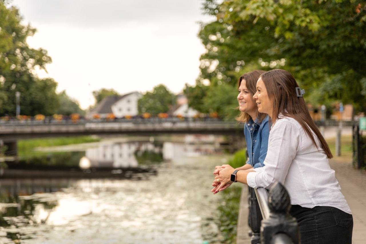 Två personer vid ett räcke intill Fyrisån i Uppsala